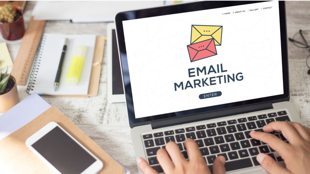 Laptop con schermata di marketing email, mani che digitano sulla tastiera.